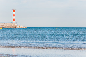 Lighthouse of Port-La-Nouvelle in red and white on cloudy sky