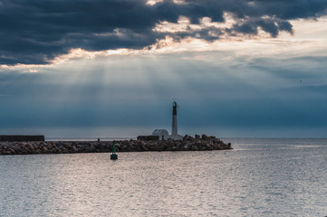 Fototapeta premium Lighthouse of Port-La-Nouvelle in red and white on cloudy sky