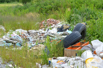 Garbage dump in nature. Abandoned old car tires in nature. Environmental pollution.