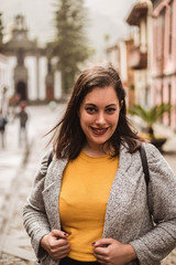 Fototapeta premium Happy hispanic woman smiling with mustard jumper