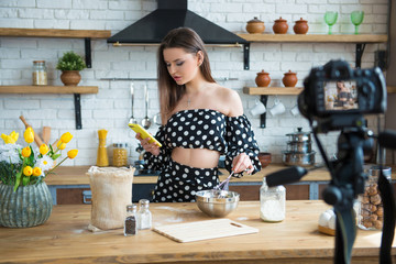 Pretty young woman girl food blogger in polka dot dress working on a new video and explaining how to cook a dish