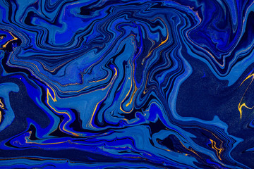 Hand painted background with mixed liquid blue and golden paints. Abstract fluid acrylic painting....