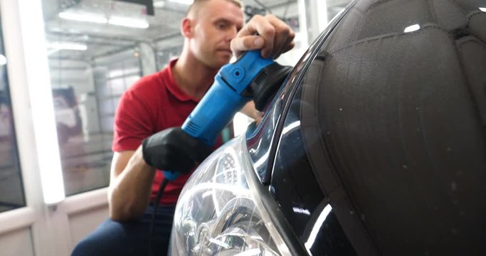 A professional bodywork and headlamp polishing worker will transport the car after painting or preparing for sale. Concept of: Freshen cars, Automotive center, Service, Professional.	