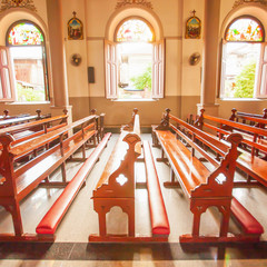 A tranquil the ancient church interior with old wooden church benches.