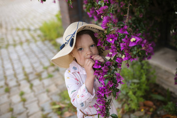 cute little girl in a hat with purple flowers