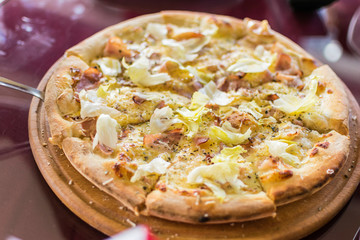 Freshly made pizza on the table. Preparing to eat.