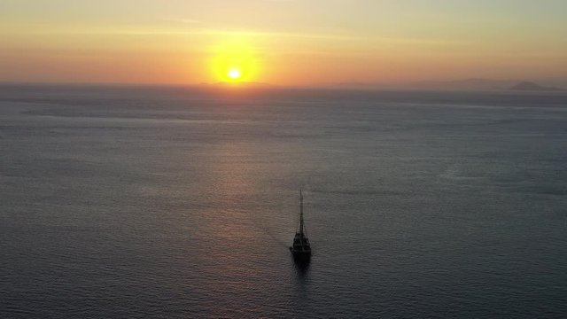 A small pinisi schooner sails at dawn in Komodo National Park, Indonesia. This tropical area is known for both its marine biodiversity as well as its infamous dragons.