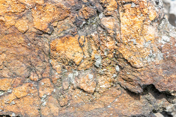 Closeup of a rock texture, with small patches of Lichen on the surface