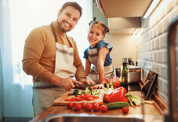 happy family father with child daughter preparing vegetable salad