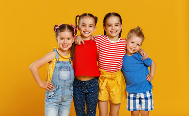 group of cheerful happy children on colored yellow background.