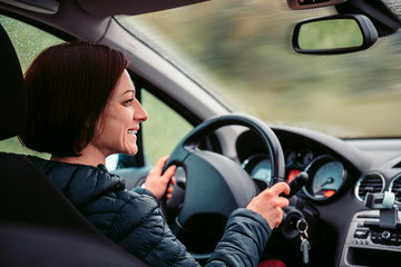 Fototapeta na wymiar Woman driving car and smiling