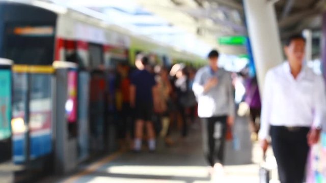 Blurry of people walking to getting on and getting out electric skytrain with automatic gateway, railroad transportation for passenger in city, traveler and urban lifestyle. BTS.