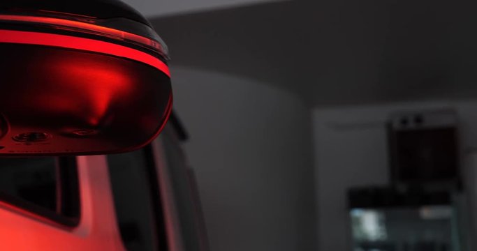 Infrared drying of car body parts after applying putty and paint on a white off-road vehicle in the body repair shop with red lanterns in the working environment. Concept of: Car Ceramic, Slow Motion.