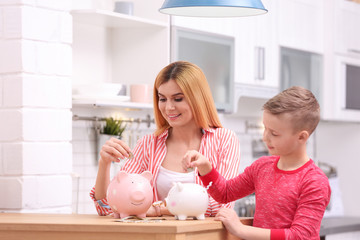 Family with piggy banks and money at home