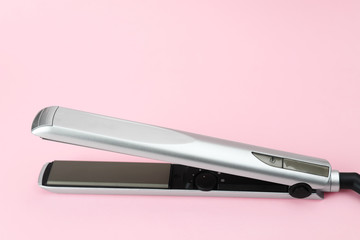 Modern hair iron for straightening on color background