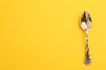 Clean tea spoon and space for text on color background, top view