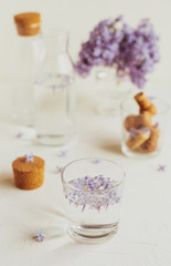 Fototapeta na wymiar Water is infused with purple spring lilac flowers 