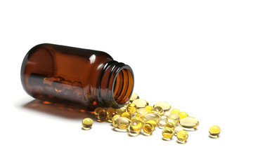 Bottle with cod liver oil capsules on white background