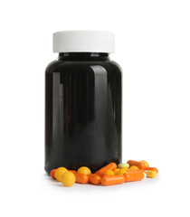 Bottle with vitamin pills and capsules on white background