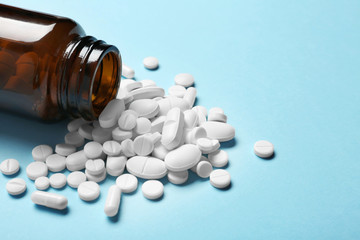 Bottle with vitamin pills on color background, closeup. Space for text