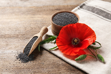 Composition with poppy seeds and flower on wooden table