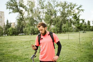 Fototapeta premium Cyclist in the park. Phone and bicycle