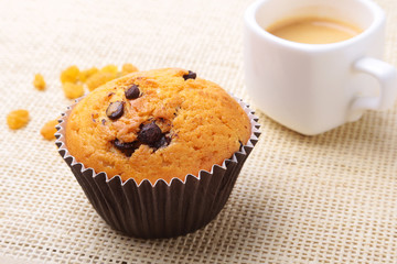 Perfect morning breakfast with Delicious homemade cupcakes with raisins, chocolate chips and espresso coffee in white cup on textile background. Muffins.