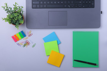 Close-up of comfortable working place in office with laptop, notebook, glasses, pen and other equipment laying on table with copy space. Top view.