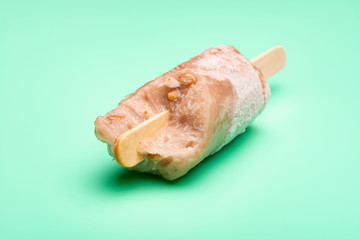 green bean popsicle on a light green background with some bites