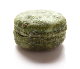 side view green moldy macaroon on a white background