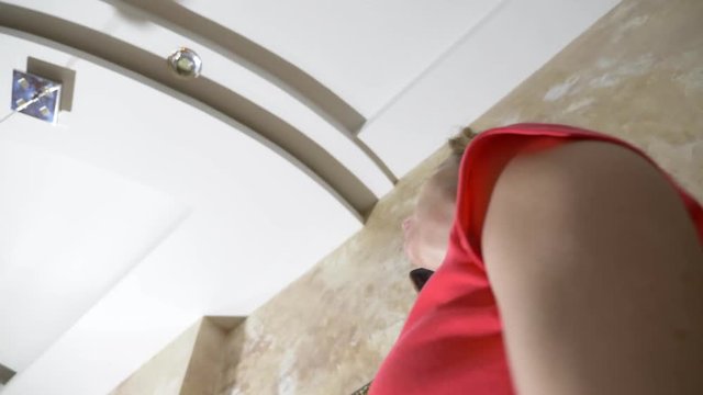 Water damage. Concept of flooding the apartment and property insurance. water drips from the ceiling in the apartment, and a woman in a fright calls telephone assistance