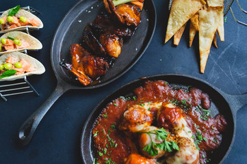 Deliciosa Variedad de platos gourmet en sarten sobre fondo oscuro, vista superior