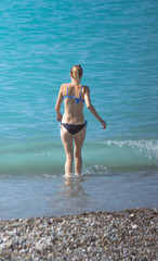 Fototapeta na wymiar girl in a swimsuit on the beach, part of the body