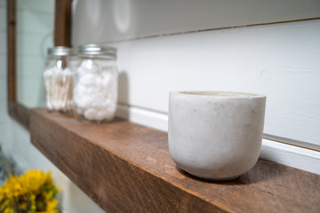 Small Cement pot cup on a rustic farmhouse bathroom shelf.