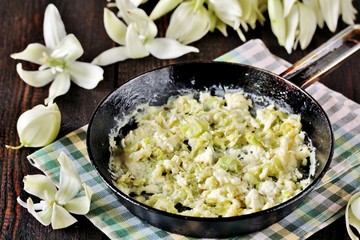 Fried yucca flower petals with eggs and tomatoes. national cuisine of Costa Rica. edible flowers recipe. Yucca is the national flower of Costa Rica