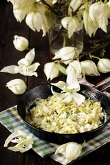 Fried yucca flower petals with eggs and tomatoes. national cuisine of Costa Rica. edible flowers recipe. Yucca is the national flower of Costa Rica