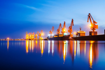 Gantry crane and cargo ship in the evening