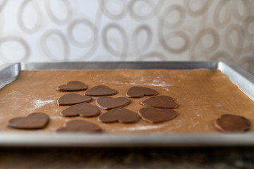 chocolate cookies in the form of heart, top view, pastry on the stove, dough preparation