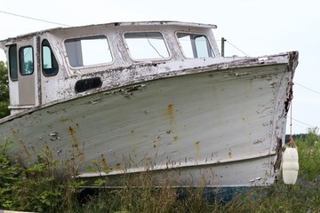 Old fisherman boat decaying on land