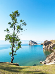 Baikal Lake summer afternoon. View of the natural attraction of Olkhon Island - Shamanka Rock and Burhan Cape. Lake natural background. Beautiful landscape