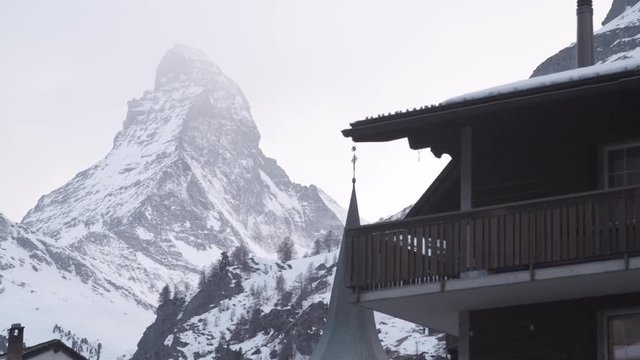 Dolly reveal of the Matterhorn behind old village roof in Zermat, Switzerland