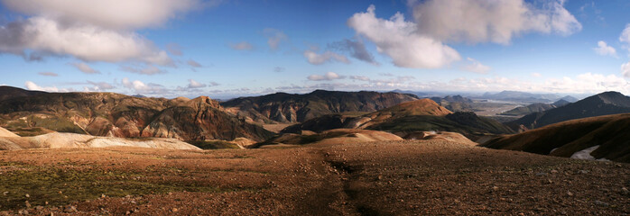 Ultra wide panorama of multi coloured mountain range on a sunny day in Landmannalaugar National Park, Iceland.