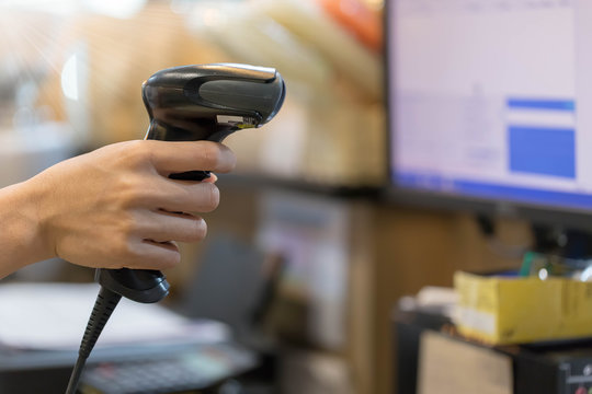 Close up barcode scanner in hand on blurred background,Inspection of goods in the warehouse,The concept of selling products in a supermarket,Spot focus,Copy space.