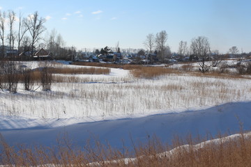 Siberian village on the Bank of the frozen riverbed in winter