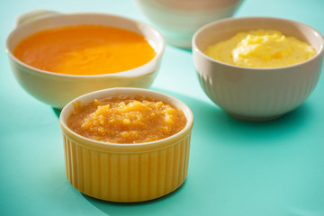 Bowls with baby food. Various bowls of fruit and vegetable puree with ingredients for cooking