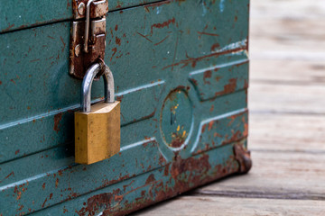 Rusty old toolbox locked up sitting on a wood