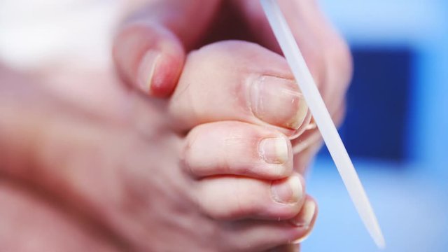 Male toenail shape with file in slow motion 4K