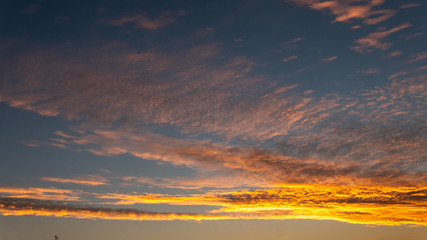 Sky blue and orange light of the sun through the clouds in the sky