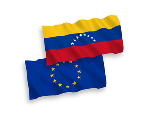 National vector fabric wave flags of European Union and Venezuela isolated on white background. 1 to 2 proportion.