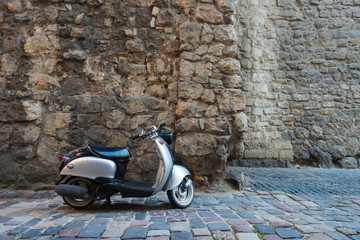 Silver scooter at street of European old city